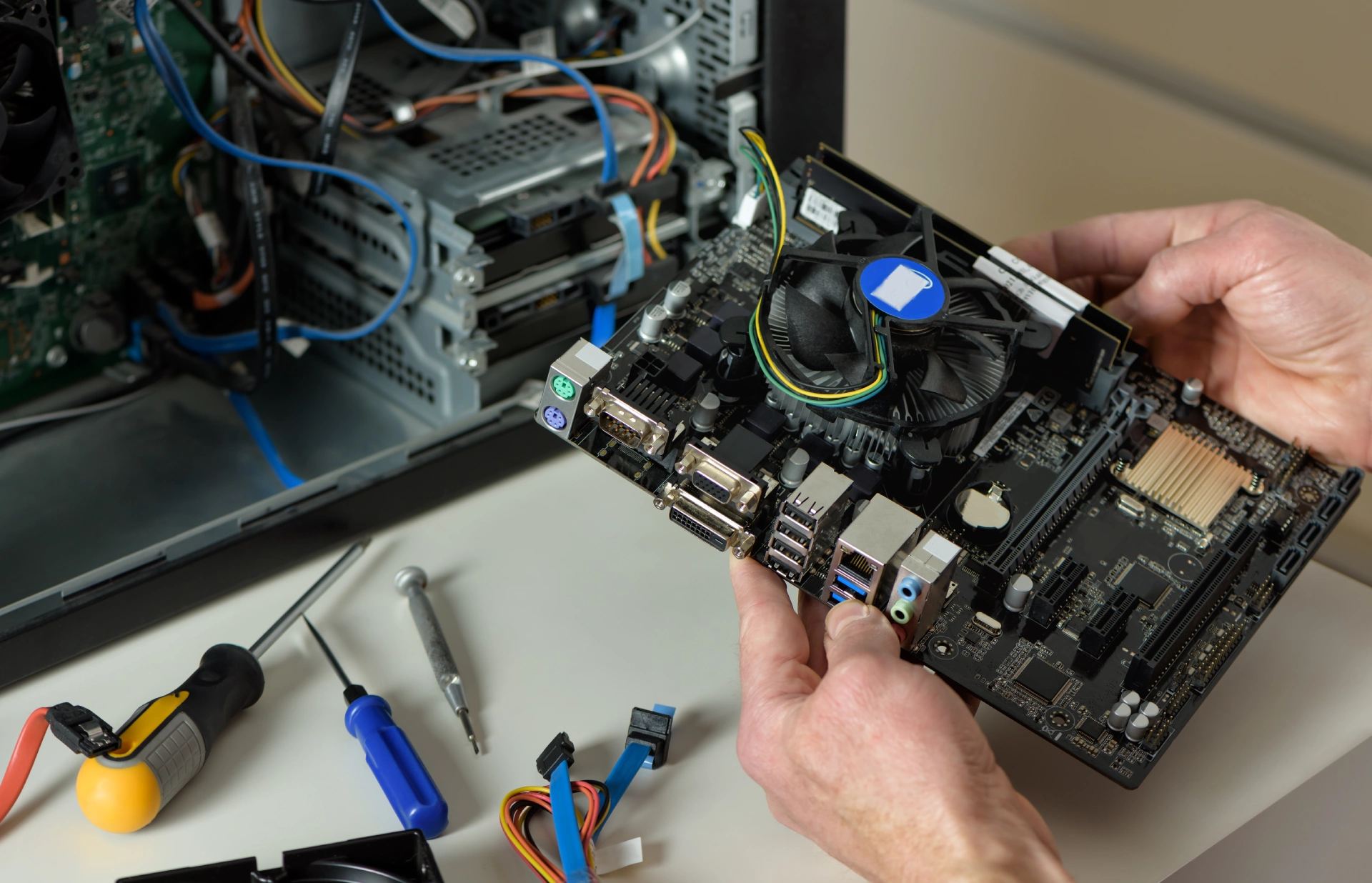 technician is holding motherboard desktop case close up